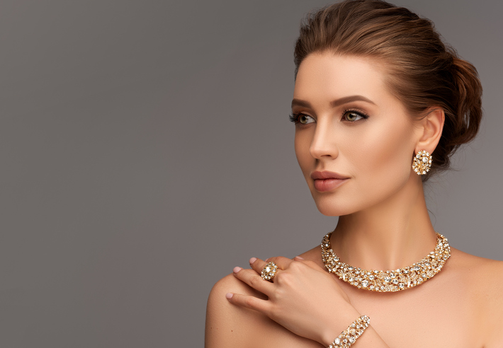 Alluring woman dressed in a posh jewelry set of necklace, ring and earrings. Elegant evening style.