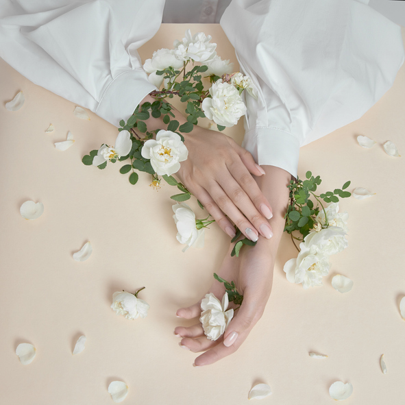 Beauty hands woman with rose flowers are on the table. Natural cosmetic for hand skin care. Fashion makeup