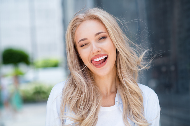 Portrait of cheerful positive funny cute girl blink eye have fun good mood enjoy nice summer weekend outdoors