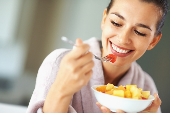 Happy woman with bowl of fruit